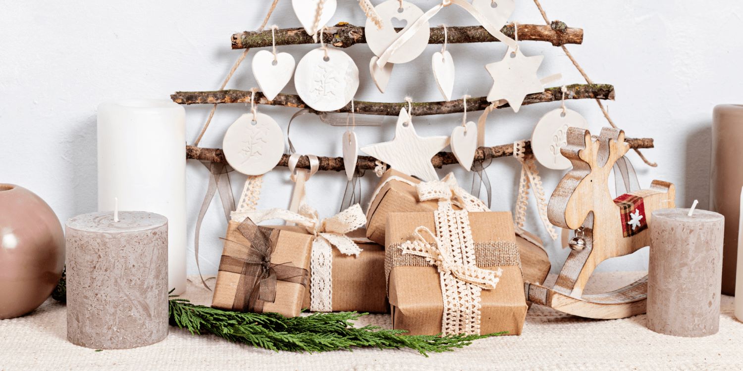 O scenă rustică de Crăciun, cu un brad minimalist realizat din crenguțe și ornamente din ceramică albă