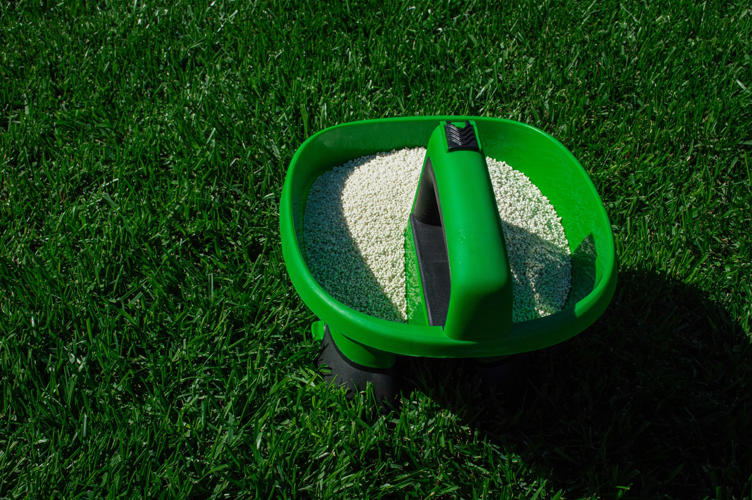 Distribuitor electric Easy Drop de îngrășământ granular pe un gazon verde